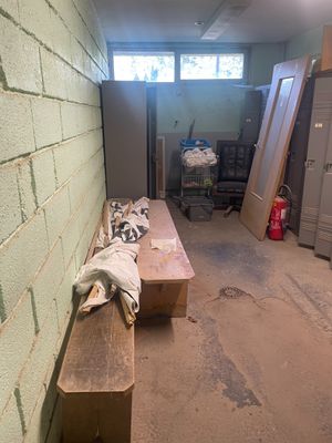 une photo d'une pièce avec un banc et des casiers