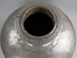 a silver vase sitting on a table with a white background