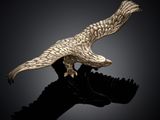 an image of a gold eagle figurine on a black surface