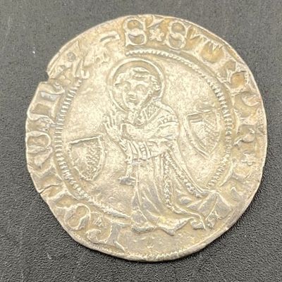 a silver coin with an image of jesus on it