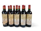 six bottles of wine are lined up on a white surface