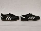 a pair of black and white adidas sneakers on a white background