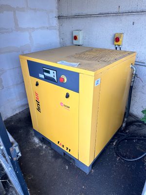 un compresseur jaune posé dans un coin d'une pièce