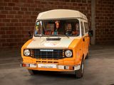 a small van that is parked in front of a brick wall