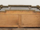 an old wooden chest with a glass top sitting on a tiled floor