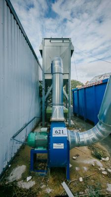 un gros tuyau situé à côté d'un conteneur bleu