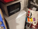 a small refrigerator and a microwave in a small room