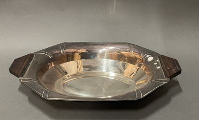 une assiette ancienne en argent avec un manche en bois sur un fond gris