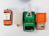 a green and orange toy truck next to a white and orange toy truck