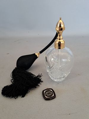 a small bottle of perfume with a tassel on the table
