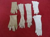 five pairs of white leather gloves on a red surface
