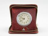 a small clock sitting inside of a case on a white surface