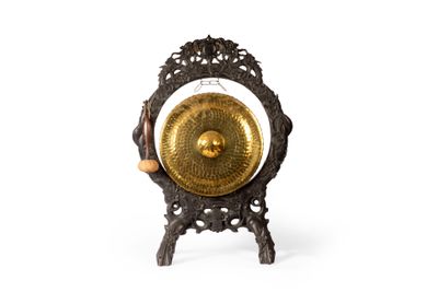 un gong doré posé sur un socle, sur une surface blanche