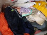 a pile of clothes in a suitcase on the floor