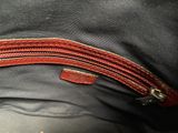 the inside of a black bag with a red zipper