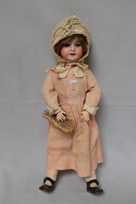 an old doll with a hat and dress holding a basket