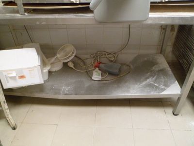 un évier de cuisine avec beaucoup de désordre par terre