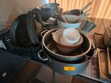 de nombreuses casseroles et poêles posées sur une table, avec des ustensiles