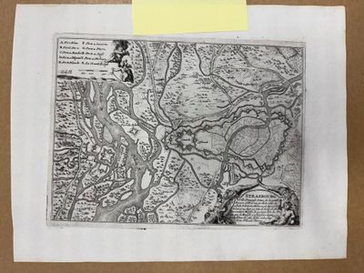 une vieille carte représentant une rivière, rangée dans une boîte sur laquelle est collé un post-it