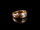 gros plan d'une bague en or avec des diamants sur une surface noire