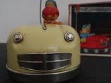 a yellow toy car with a red hat on top of it