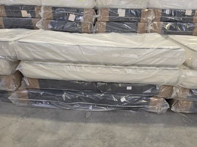 a lot of mattresses stacked on top of each other in a warehouse