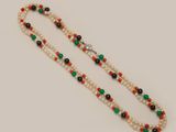 a close up of a beaded necklace on a white surface