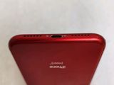 the back of a red cell phone sitting on top of a white surface