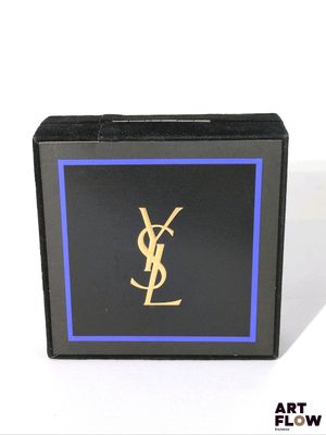 un gros plan d'une boîte noire ornée d'un logo YSL doré