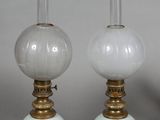 trois lampes en verre blanc posées les unes à côté des autres sur une table