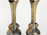two vases that are sitting side by side on a white surface