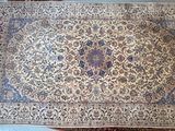 une photo d'un grand tapis oriental posé sur une table en bois