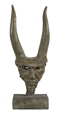 statue of a horned head with horns on a wooden base