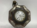 a small clock with roman numerals on the face