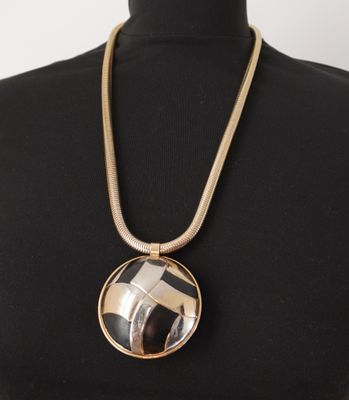 une femme portant un collier orné d'une photo en noir et blanc