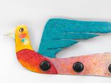 a colorful bird that is sitting on top of a wall