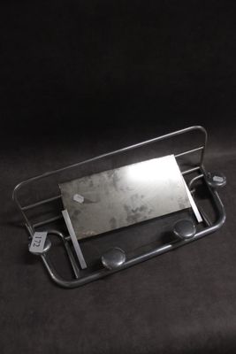 un plateau métallique orné d'un miroir, sur fond noir