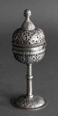 an old silver object with a bird on top of it