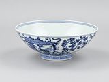 a blue and white bowl with a dragon design on the rim
