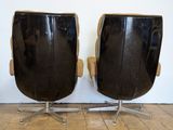 pair of black leather lounge chairs with chrome steel legs and arms
