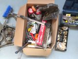 une boîte remplie d'objets et d'outils divers posée par terre
