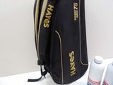 a black bag with a gold logo on it next to a bottle of water