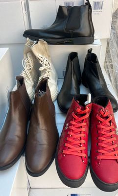 Quatre paires de chaussures pour homme sont alignées sur une boîte