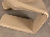 beige leather chair and foot rest on a gray floor
