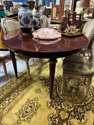 une table avec des chaises et un vase posé dessus