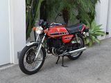a red motorcycle parked in front of a white building