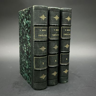 trois livres empilés les uns sur les autres sur une surface grise