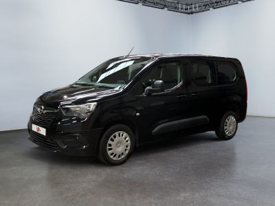 La camionnette noire est garée dans une grande pièce aux murs blancs.