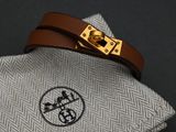 a brown leather bracelet with a gold buckle on it