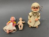 two figurines of a man and a woman with a baby
